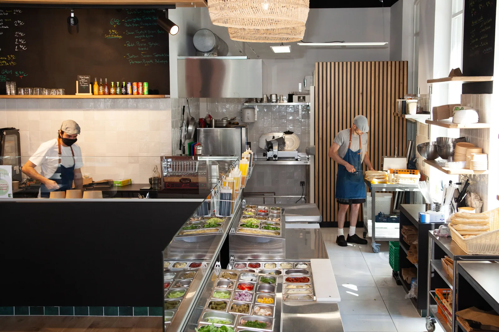 L'équipe prépare les commandes derrière le bar à salades